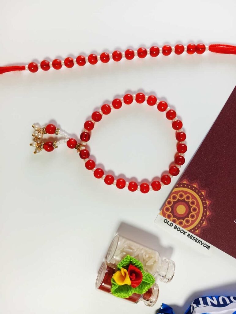Lumba Rakhi Gift Box for Bhaiya Bhabhi: Red Beads & Pearl Crafted Rakhi Gift Set